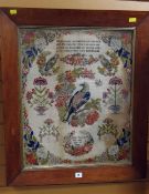 An antique woolwork sampler with the depiction of birds & flowers with needlework prose and