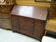 An antique mahogany sloped bureau with a bank of five drawers, the interior composed of pigeon