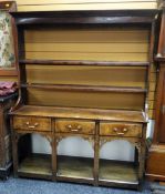 An attractive small antique mixed wood Welsh dresser having a solid platform base, three drawers, an