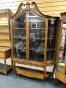 An attractive antique dome-top satinwood display cabinet having a frontage of two glazed doors &