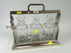 A three-bottle white metal tantalus Condition Report: please request* *Condition is not stated in