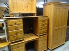 A suite of pine furniture comprising double wardrobe, dressing tables, bookcase and bed ends