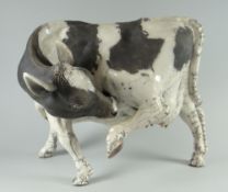 A raku pottery model of a standing cow by LAWSON C RUDGE, signed, 28cms long Condition Report: