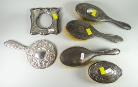 A parcel of part-silver items comprising three brushes, a silver backed hand mirror, Art Nouveau