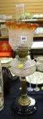 An antique oil lamp with black pottery base, Corinthian brass column stem & pink swirl glass