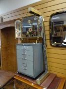 A folding painted mirror-glass firescreen, a small filing cabinet & an antique brass fender