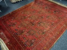 A large Middle Eastern woollen red ground geometric patterned rug, 254 x 193cms Condition Report: