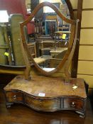 An antique serpentine front shield-shaped toilet mirror with drawers, together with a brass fender