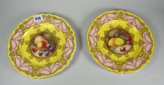 A pair of Royal Worcester porcelain plates by Richard Sebright in yellow ground & with salmon pink