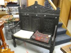 An antique ebonized carved settle with three-panel back, 120wx59dx137h cms Condition Report: