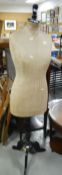 A three quarter size vintage mannequin stamped 'Selfridges, London' on an ebonized tripod base,