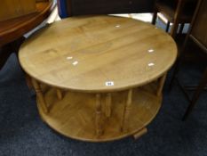 Pale oak circular two-tier coffee table having turned spindle supports with overall inscription to