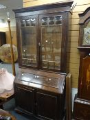 A vintage oak bureau bookcase with glazed doors above cupboard base, 214cms high x 110cms wide x