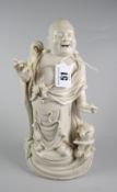 CHINESE BLANC DE CHINE FIGURE OF A STANDING BUDDHA ON HARDWOOD OVAL BASE unmarked, 26cms high