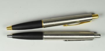 TWO MODERN STAINLESS STEEL PARKER FRONTIER BALLPOINT PENS one with gold plated trim