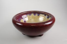 CHINESE CIRCULAR BOWL in sang de boeuf glaze, raised on three nipple-like feet, unmarked, 18.5cms
