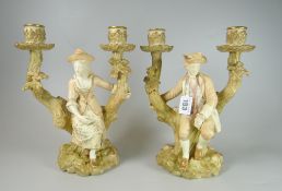 A PAIR OF ROYAL WORCESTER FIGURALTWIN CANDLE-HOLDERS in the form of lady and gentleman seated on