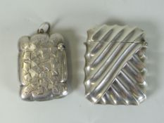 TWO SIMILAR SILVER VESTA CASES, one of raised rib design and the other overall engraved and named 