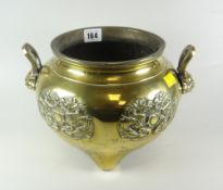 A CHINESE POLISHED BRONZE TWIN-HANDLED TRI-FOOT CENSER with relief dragon decoration and lion