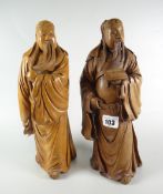 TWO SIMILAR CARVED HARDWOOD FIGURES OF CHINESE OFFICIALS one holding book, the other holding his
