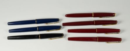 SEVEN VINTAGE PARKER 17 FOUNTAIN PENS one black, two blue, four red, all with gold trim also one red