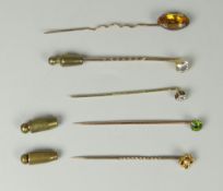 FIVE YELLOW METAL TIE PINS to include gold, smoky quartz, flower head diamond, emerald etc