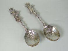 PAIR OF CONTINENTAL SILVER FIGURAL SPOONS having floral and foliate decorated bowls terminating with