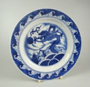 CHINESE PORCELAIN BLUE & WHITE SHALLOW DISH depicting four clawed dragon chasing a flaming pearl