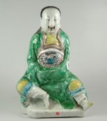 JAPANESE PORCELAIN FIGURE OF A SEATED MAN IN DRAGON ROBES unglazed to base & unmarked, old Bluett