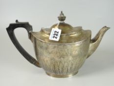 VICTORIAN SILVER OVAL TEAPOT having half body leaf decoration with ebonized handle and finial.