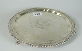 GEORGE V SILVER CIRCULAR SALVER having pie crust edge and raised on three hoof feet. Engraved with