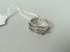 18CT WHITE GOLD DIAMOND CHIP AND RUBY RING of spiral three prong design, 3.6 grams, in box.