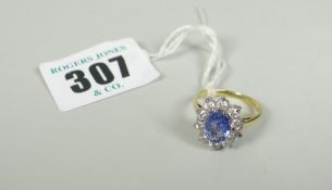 18CT YELLOW GOLD SAPPHIRE AND DIAMOND RING the oval sapphire surrounded by ten diamonds, 3.9 grams