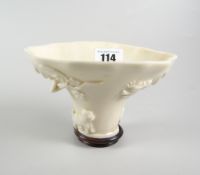 CHINESE BLANC-DE-CHINE LIBATION CUP ON HARDWOOD STAND the cup depicting fish, animals & dragon,