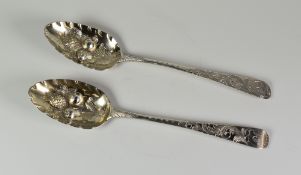 TWO SIMILAR EARLY 19TH CENTURY SILVER BERRY SPOONS, with embossed and engraved decoration and