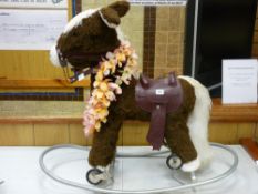A child's ride on rolling/rocking pony with saddle