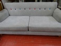 An ultra modern upholstered settee with colourful button back detail
