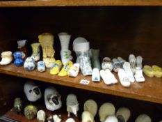 A collection of decorative porcelain shoes, clogs etc