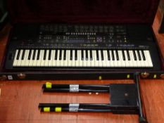 A Yamaha PSR-410 battery operated piano accordion with a small portable stand