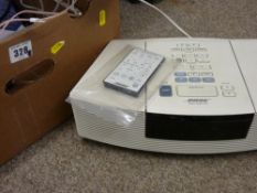 A Bose soundwave system with remote control and a desk lampE/T