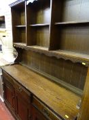 Dark wood dresser with sectional top and carved detail to base cupboards
