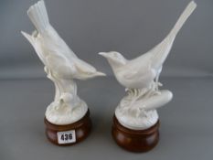 Two Continental porcelain birds on wooden plinths