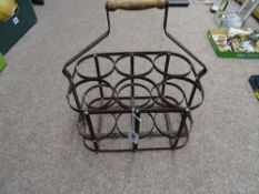 A vintage wooden handled iron bottle carrier