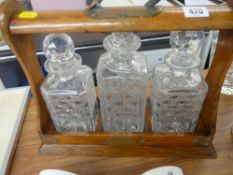 Victorian oak three bottle tantalus with key (bottles not matching)
