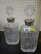 Pair of square glass decanters with stoppers and silver plated collars