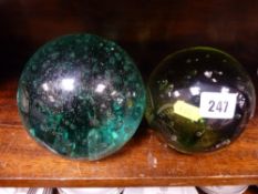 Two large globular green glass dump doorstops