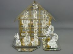 Collection of Swarovski and other crystal animal figurines with a brass and glass mirrored display