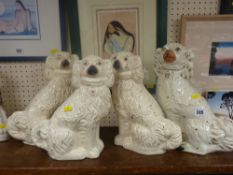 Group of four white pottery Staffs comforter dogs