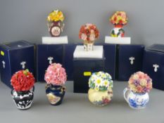 Collection of boxed ornamental flowers in vases, patterned after famous makers