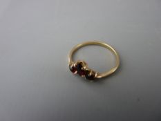 Small nine carat gold ring set with three small garnet type stones